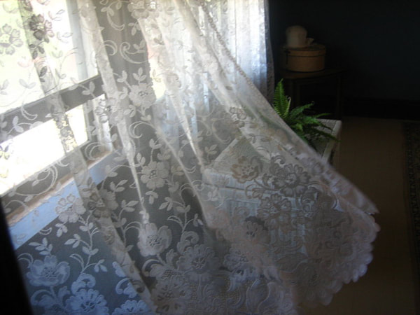 An open window and a net curtain blowing into a cornucopia