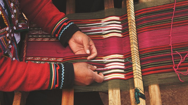 An Indian weaving a blanket