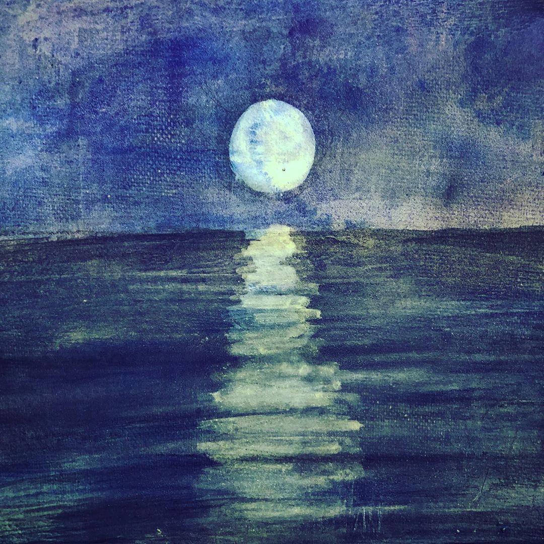 The moon shining across a lake